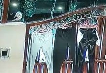 PASSERBY WALKS AWAY WITH PANTS LEFT OUT TO DRY AT THE GATE